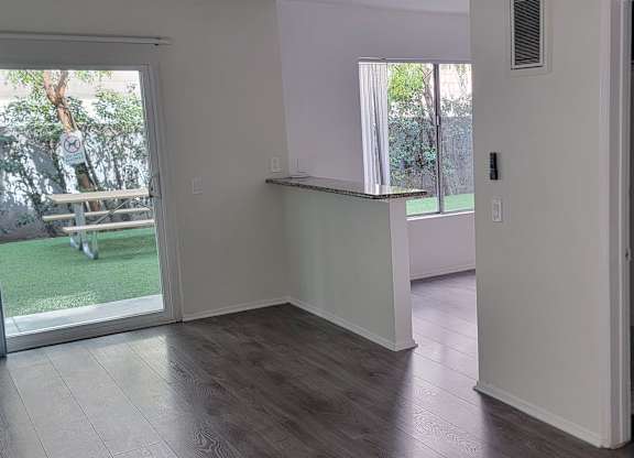 A room with a sliding glass door leading to a backyard.