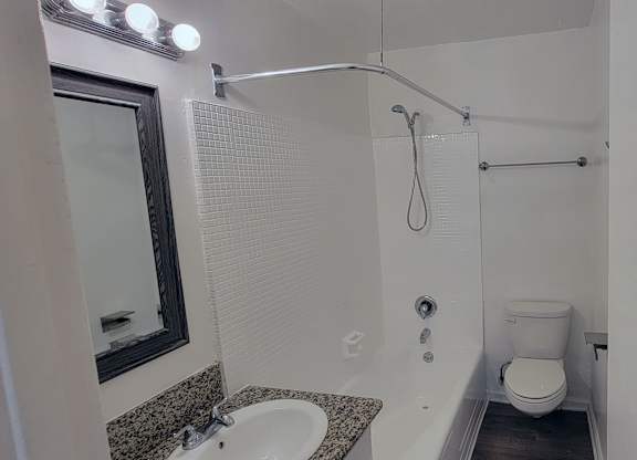 A bathroom with a toilet, sink, and shower.