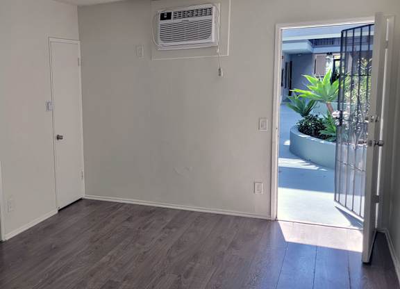 A room with a white wall and a door on the left side.