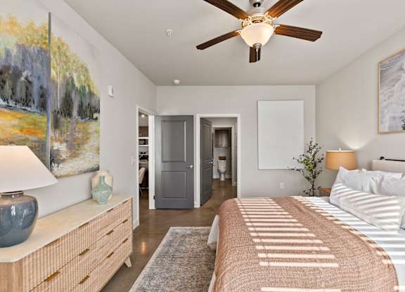 A bedroom with a large bed and a ceiling fan.