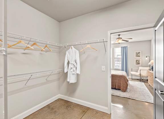 A white bathroom with a white robe hanging on a hanger.