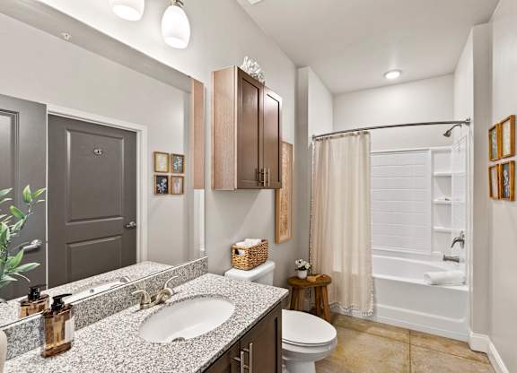 A bathroom with a white tub and a white toilet.