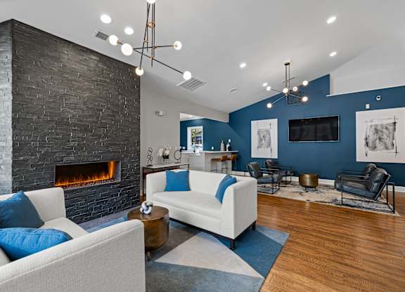 A modern living room with a fireplace and a white couch.