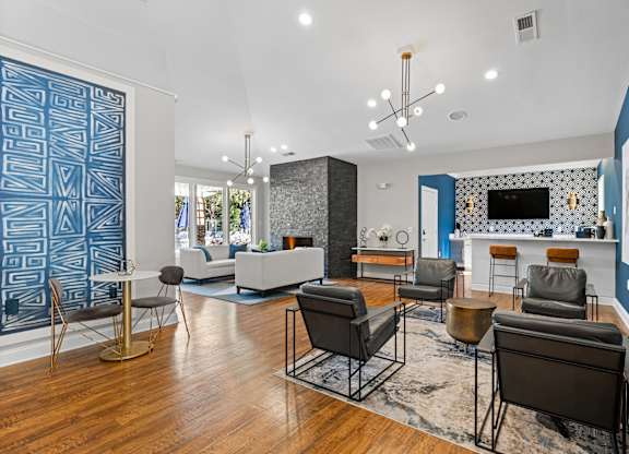 A living room with a blue accent wall and a patterned blue wallpaper.