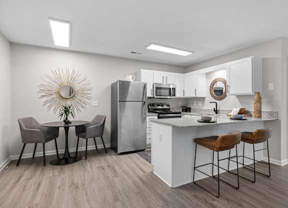 A kitchen with a table and chairs.