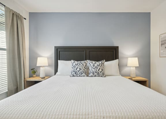 a bedroom with a large bed and two night stands with lamps
