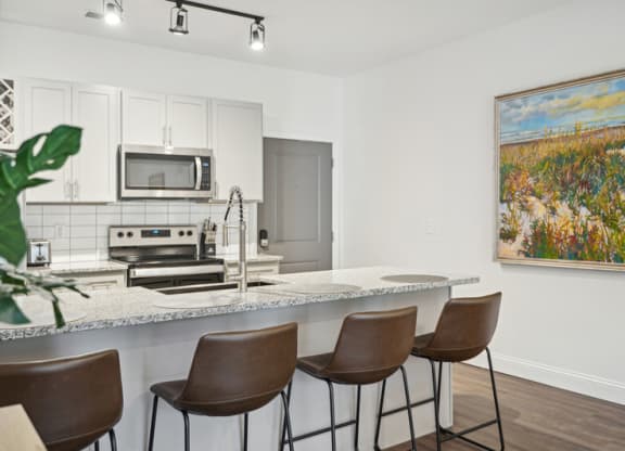 a kitchen with a marble counter top with bar stools