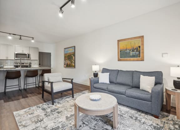a living room with a couch and a table and a kitchen