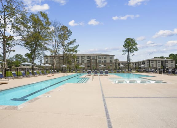 a swimming pool with umbrellas and buildings in the background