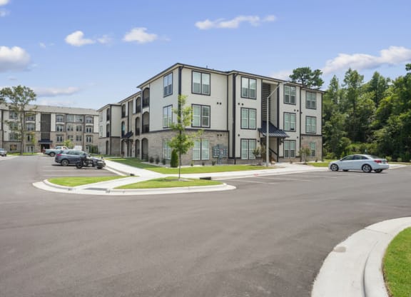 a large apartment building with cars parked in front of it