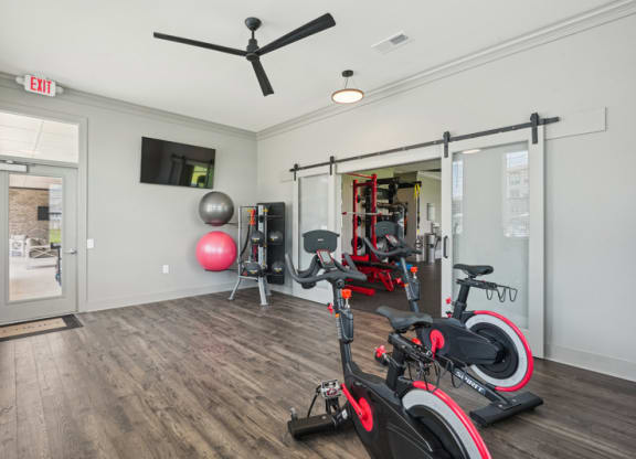 the residence apartments fitness center with exercise equipment and tv