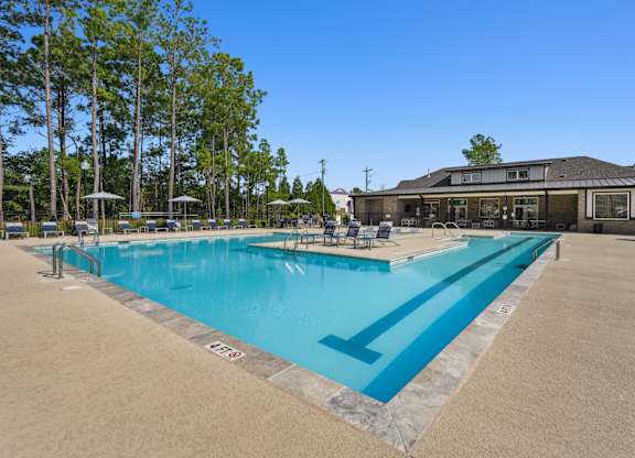 A large outdoor swimming pool with a building in the background.
