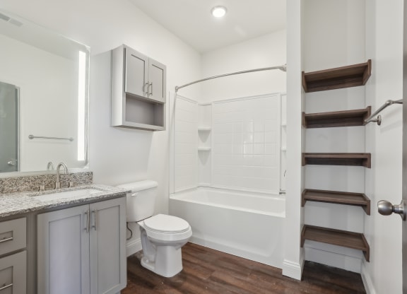 a white bathroom with a shower toilet and sink