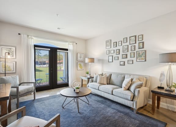 a living room with a couch and a table   and a balcony