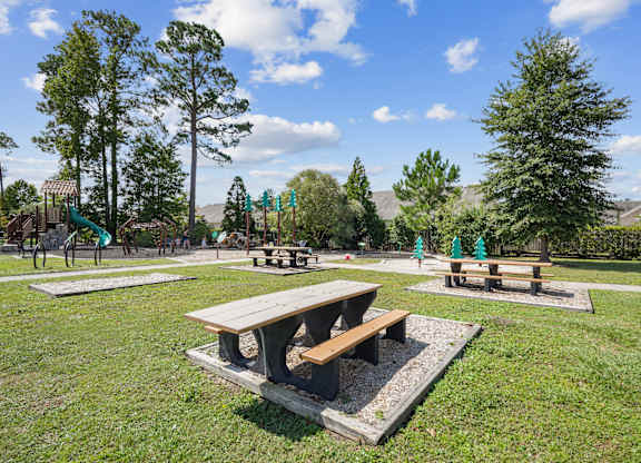 A park with picnic tables and trees.