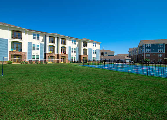 Apartment complex with a green lawn in front.