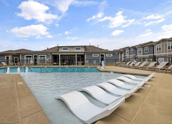 Large pool with white pool chairs in the shallow end