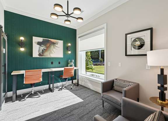 A room with a green wall and a window overlooking a green field.