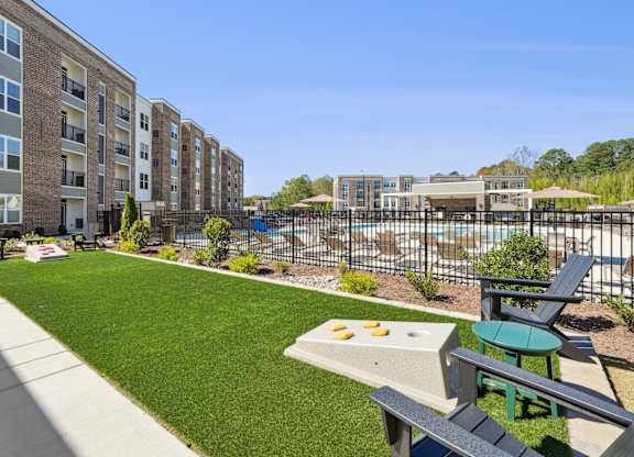 A sunny day at a residential complex with a pool and a picnic table.