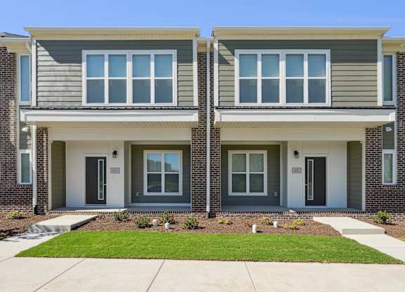 A modern two-story house with a grey and white exterior.