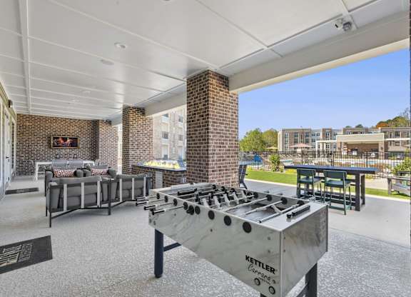 A Kettler outdoor grill is in the foreground of a patio area.