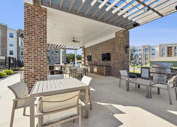 A patio with a table and chairs under a roof.