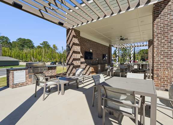 A patio with a table and chairs under a roof.