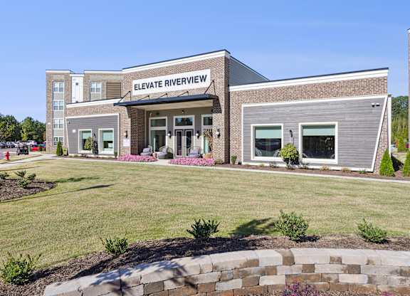 The front of the Elevate Riverview building is shown with a clear blue sky in the background.