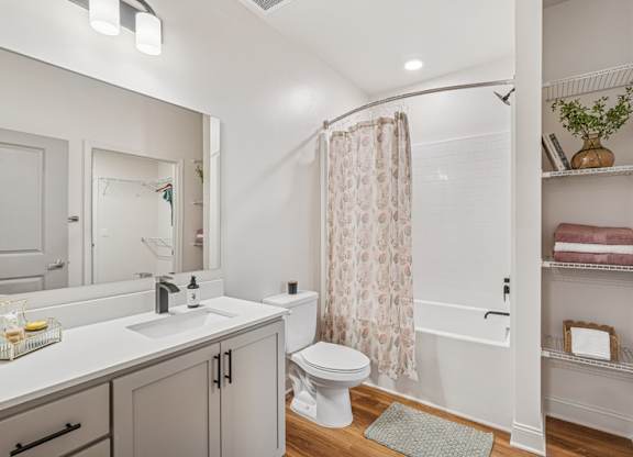 A white bathroom with a toilet, sink, and shower.