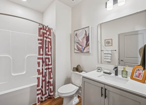 A bathroom with a toilet, sink, and shower.