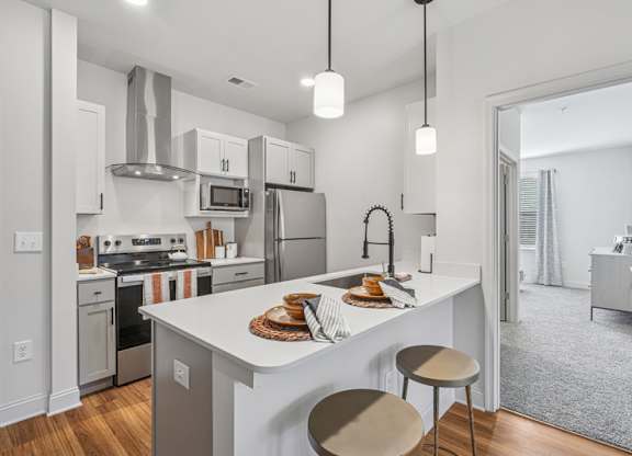 A modern kitchen with a white island and stainless steel appliances.