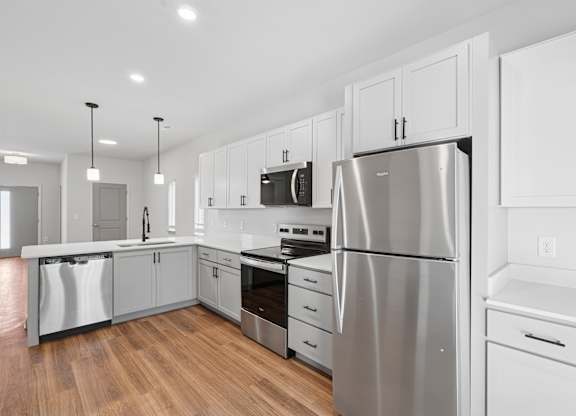 A modern kitchen with stainless steel appliances and white cabinetry.
