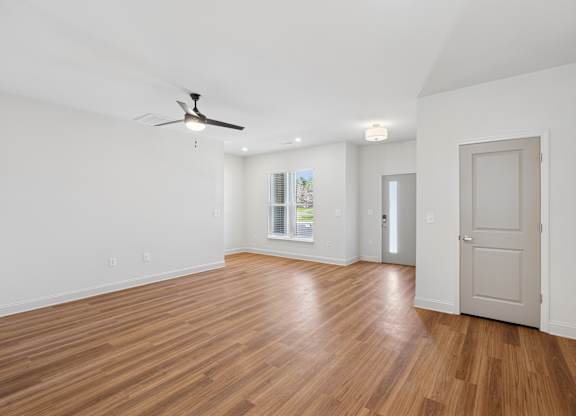 A room with wooden floors and a ceiling fan.