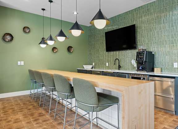 A kitchen with green walls and a wooden island.