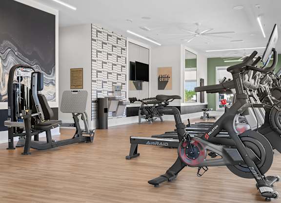 A gym with a rowing machine in the foreground.