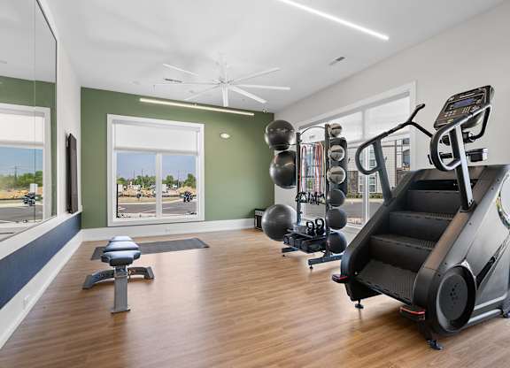A home gym with a treadmill, exercise balls, and weights.