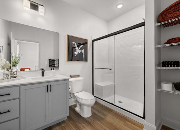 A bathroom with a toilet, sink, and a cabinet.