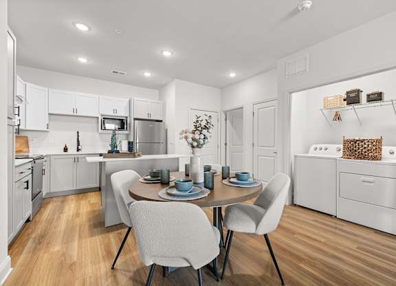 A modern kitchen with a dining table set for two.