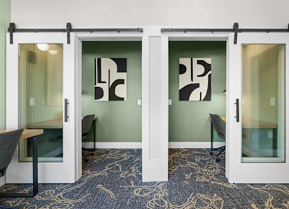 A room with a patterned carpet and a glass wall with a sliding door.