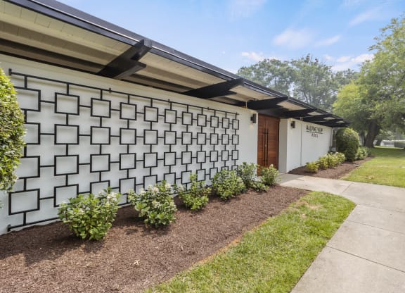 a white building with a white garage door and a white facade with a black roof and a