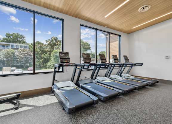 A gym with treadmills and a bench.
