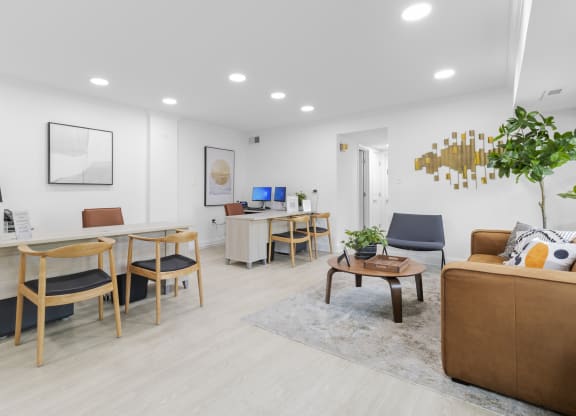 a common room with a desk and chairs and a couch