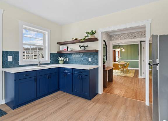 A kitchen with blue cabinets and a window.