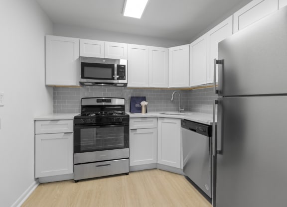 a kitchen with stainless steel appliances and white cabinets