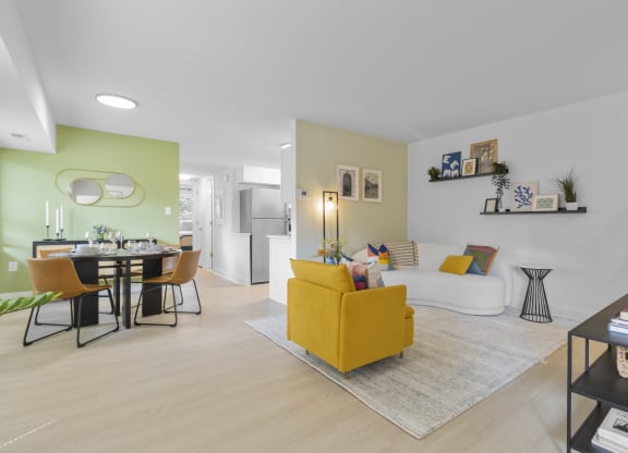 a living room and dining room with a yellow couch and yellow chairs