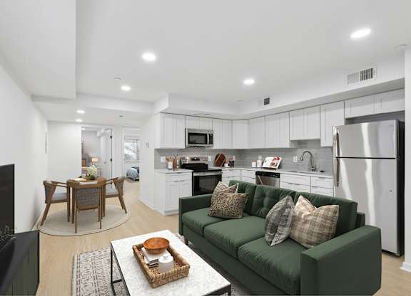 A modern kitchen with a green couch and a coffee table.