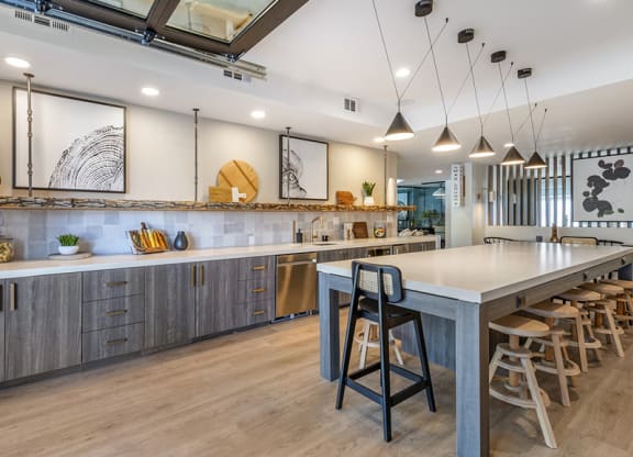 a large kitchen with a long counter and chairs