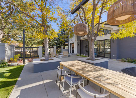 A modern outdoor patio with a wooden table and chairs.
