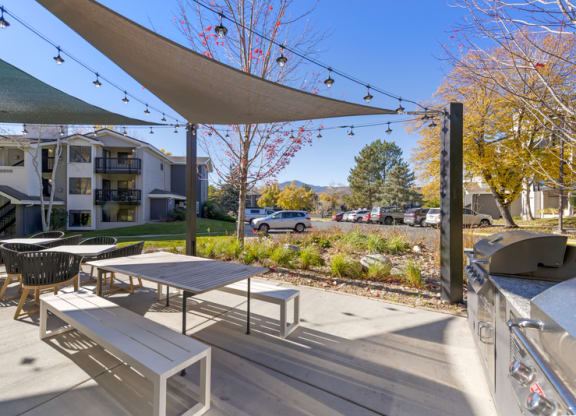 a patio with tables and chairs and a grill