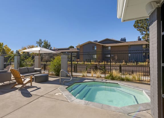 our apartments have a resort style pool with chairs and an umbrella